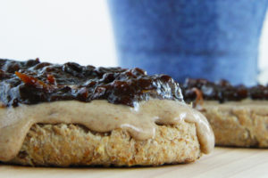 This sprouted grain english muffin topped with raw almond butter and homemade prune jelly is a high protein vegan snack