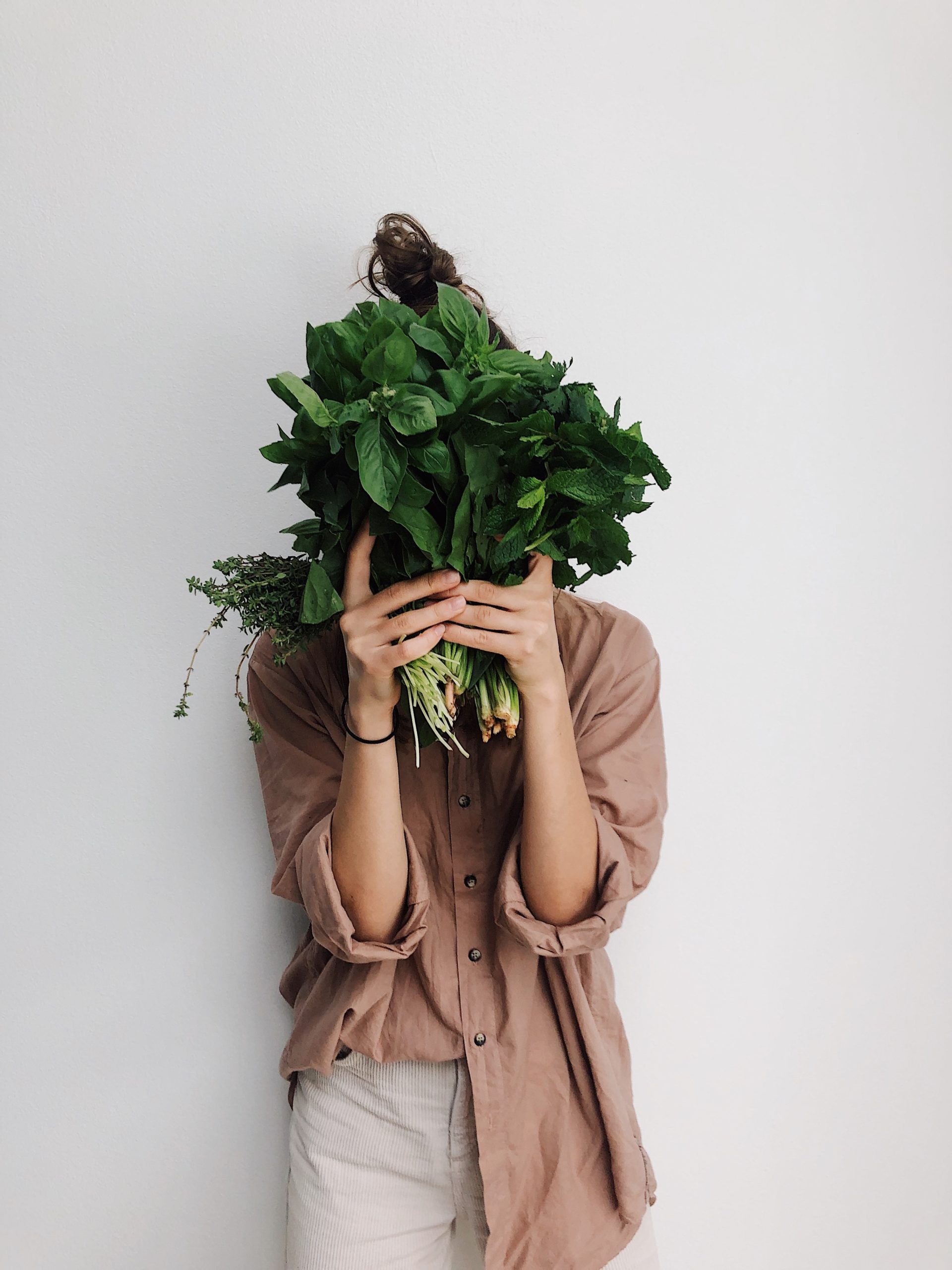 Person holding a bunch of green leafy vegetables